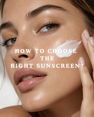 Gros plan beauté d'une femme à la peau lumineuse et naturelle, en train d'appliquer une touche de crème solaire sur sa joue.